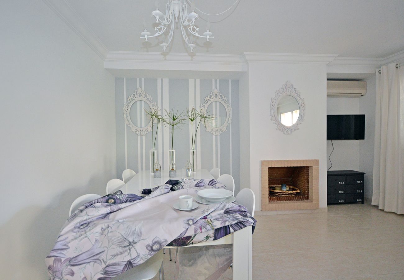 Living-dining room with table and fireplace at the Salada house, near the beach in Alcúdia